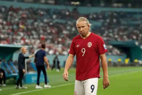 Grounded editorial scene illustrating Norway’s surprising substitution of star striker Erling Haaland during extra time in their 2-1 World Cup quarterfinal defeat to England drew widespread criticism online.
