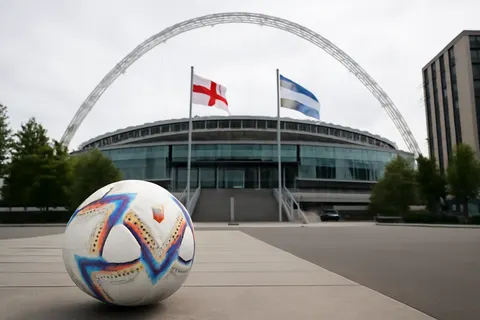 Grounded editorial scene illustrating England advances to the World Cup semi-finals, setting up a historic clash with reigning champions Argentina, as coach Thomas Tuchel praises the team's determination while calling for further improvement.