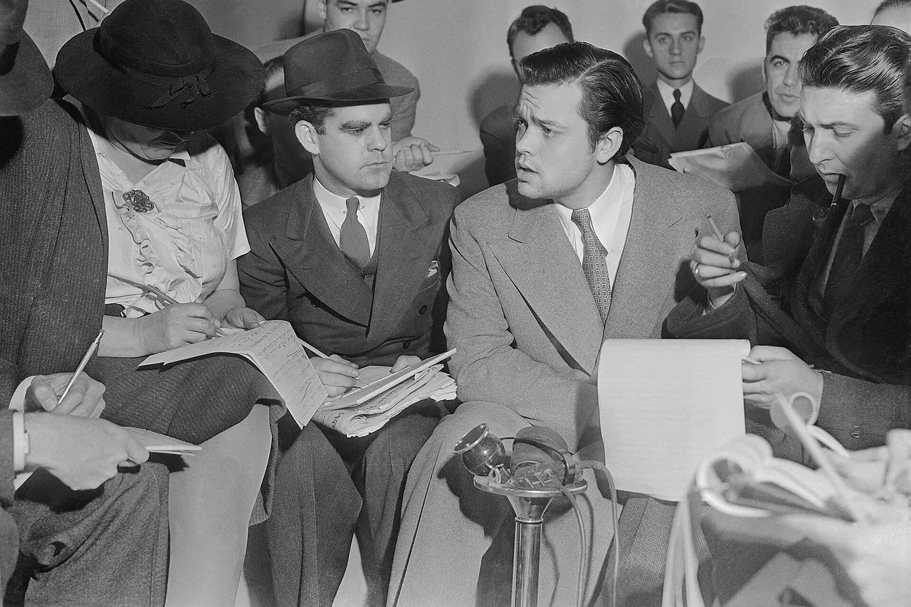 Photo of Orson Welles meeting with reporters in an effort to explain that no one connected with the War of the Worlds radio broadcast had any idea the show would cause panic.