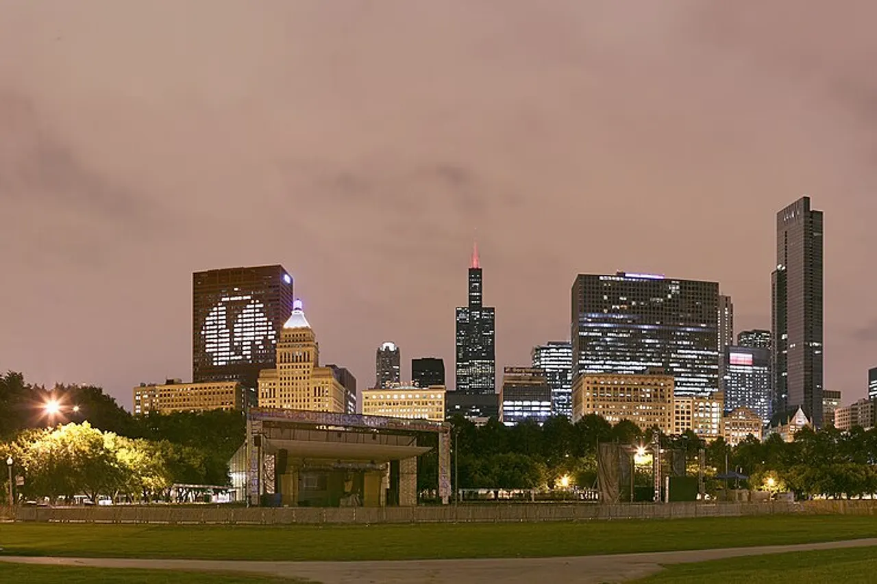 Chicago skyline with the CNA Center showing the Chicago Blackhawks ' logo, the Smurfit Stone Building saying "Go Hawks" and the Blue Cross Blue Shield Tower saying "Hawks Win" the night after the 2009–10 Chicago Blackhawks won the 2010 Stanley Cup Finals , viewed from the Petrillo Music Shell lawn in Grant Park .