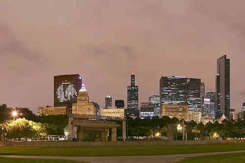 Chicago skyline with the CNA Center showing the Chicago Blackhawks ' logo, the Smurfit Stone Building saying "Go Hawks" and the Blue Cross Blue Shield Tower saying "Hawks Win" the night after the 2009–10 Chicago Blackhawks won the 2010 Stanley Cup Finals , viewed from the Petrillo Music Shell lawn in Grant Park .