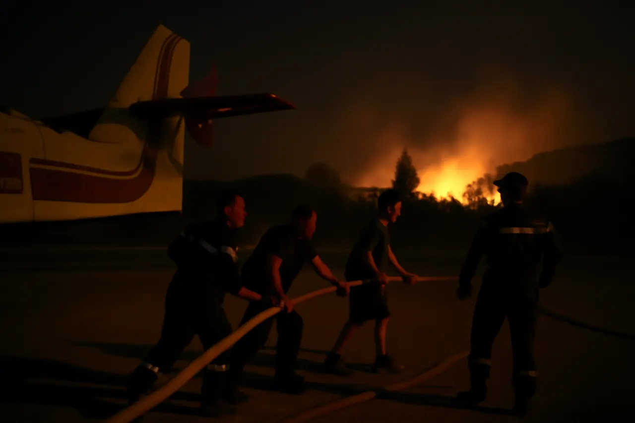 Grounded editorial scene illustrating With Canadair aircraft grounded due to low visibility, firefighters and residents work together on the ground to battle the blaze.
