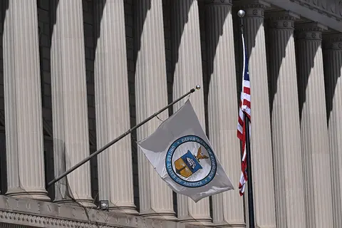 The United States Department of Commerce flag blowing in the wind outside the Herbert C. Hoover headquarters building. 1401 Constitution Avenue NW, Washington, DC 20230.