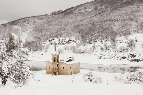 Submerged church of St. Nicholas, Mavrovo Lake , North Macedonia . The church was built in 1850 and submerged in the local lake in 1953, but due to droughts in the 21st century it has largely appeared out of the lake.