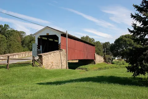 A three-quarters view photograph of the Weaver's Mill Covered Bridge . Camera and Exposure Details: Camera: Nikon D50 Lens: Tokina 12-24mm f/4 Exposure: 24mm (36mm in 35mm equivalent ) f/11 @ 1/125 s. (200 ISO)