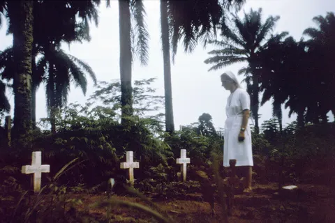"This photograph showed Sister Marietta as she walked among the grave sites of her colleagues that had perished during the Zaire (now known as the Democratic Republic of the Congo) Ebola outbreak of August, 1976. The Flemish nuns, and the African hospital Staff of a Yambuku, Zairian mission hospital treated the first known patient of one of the world’s deadliest diseases, Ebola hemorrhagic fever (Ebola HF). The virus traveled quickly, and a large number of the mission members and patients died in the fall of 1976."