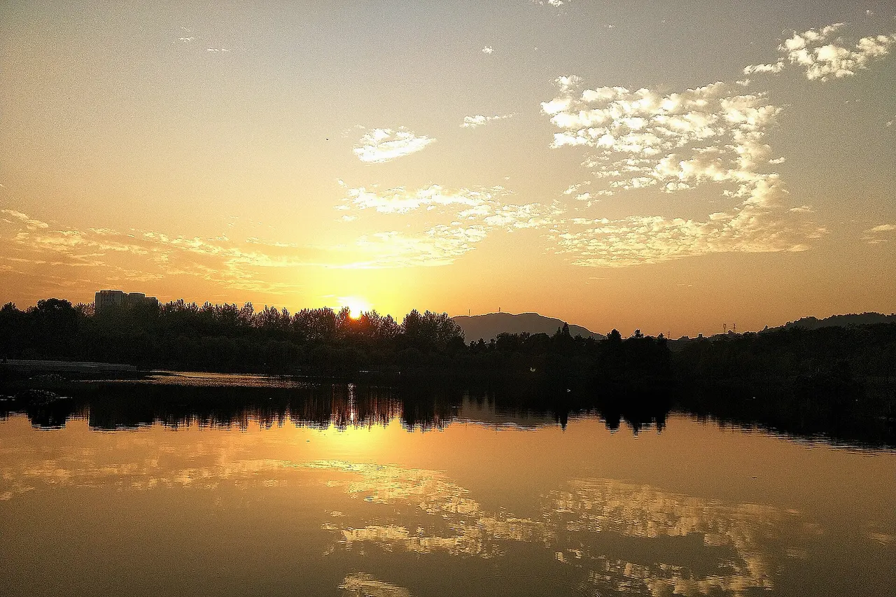 ​浙江农林大学东湖在黄昏时的照片，夕阳几乎完全沉入地平线下。
