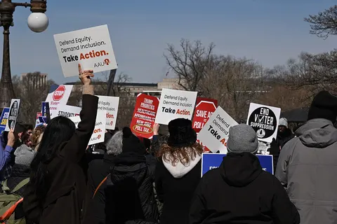 A crowd of people holding signs at the "Stop the SAVE Act" rally at the United States Capitol building in Washington, DC.