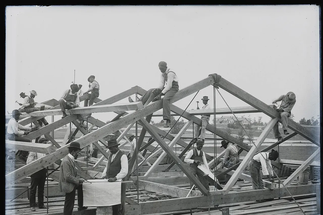 Photograph shows students of the Tuskegee Institute, Tuskegee, Alabama building a roof.
