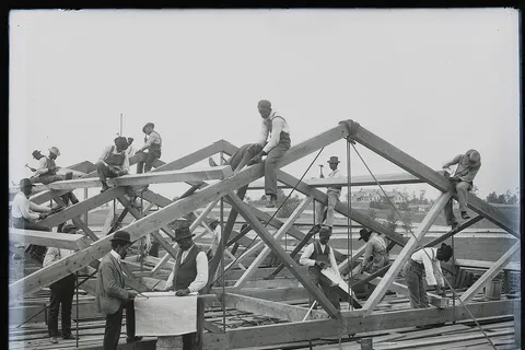 Photograph shows students of the Tuskegee Institute, Tuskegee, Alabama building a roof.
