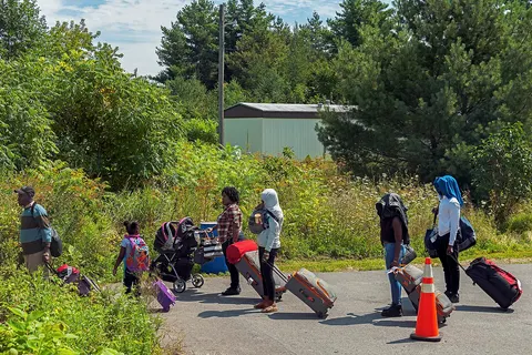 Asylum seekers preparing to cross the US-Canadian border from the end of Roxham Road in the town of Champlain, NY