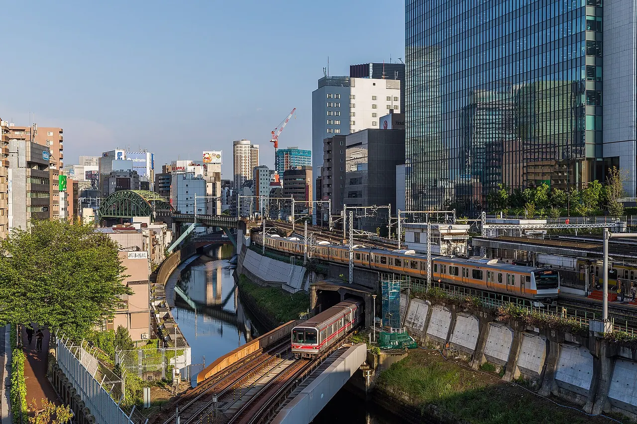 Tokyo Metro 02 series nr. 618 (below) on the Marunouchi Line crosses the Kanda river, while, above, a E233 set of JR East on the Chuo main line just leaves Ochanomizu. If you look closely, you can also spot a E231 set of JR east on the Sobu line, behind the platform. Photo taken at Ochanomizu, Tokyo, Japan.