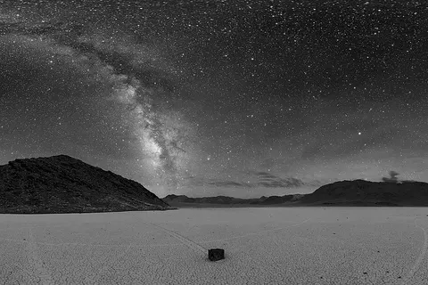 360° panorama of Racetrack Playa in Death Valley at night. The Milky Way is visible as the arc in the center. A sailing stone is also seen below along with the tracks of other stones.