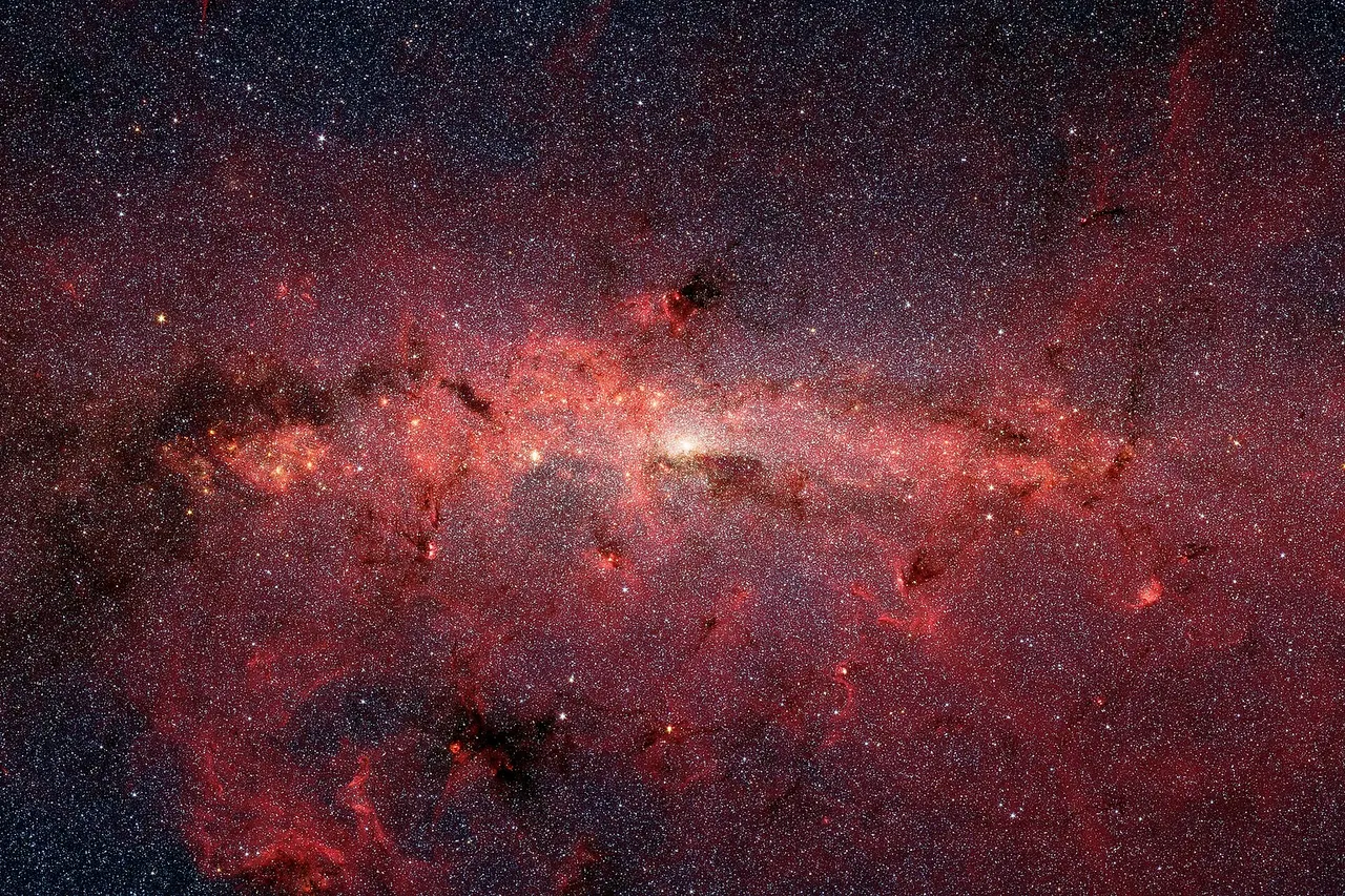 The center of our Milky Way galaxy is hidden from the prying eyes of optical telescopes by clouds of obscuring dust and gas. But in this stunning vista, the Spitzer Space Telescope's infrared cameras penetrate much of the dust, revealing the stars of the crowded galactic center region. The upcoming James Webb Space Telescope will offer a much-improved infrared view, teasing out fainter stars and sharper details. The center of our galaxy is a crowded place: A black hole weighing 4 million times as much as our Sun is surrounded by millions of stars whipping around it at breakneck speeds. This extreme environment is bathed in intense ultraviolet light and X-ray radiation. Yet much of this activity is hidden from our view, obscured by vast swaths of interstellar dust. NASA’s James Webb Space Telescope is designed to view the universe in infrared light, which is invisible to the human eye, but is very important for looking at astronomical objects hidden by dust. After its launch, Webb will gather infrared light that has penetrated the dusty veil, revealing the galactic center in unprecedented detail.