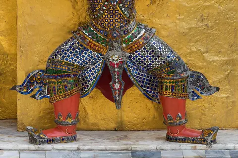 Statue of Yaksha (in the Ramakien , broad class of nature-spirits, usually benevolent, but sometimes mischievous or capricious, connected with water, fertility, trees, the forest, treasure and wilderness) supporting the base of one of the Two Golden Chedi of Wat Phra Kaew , Bangkok , Thailand .