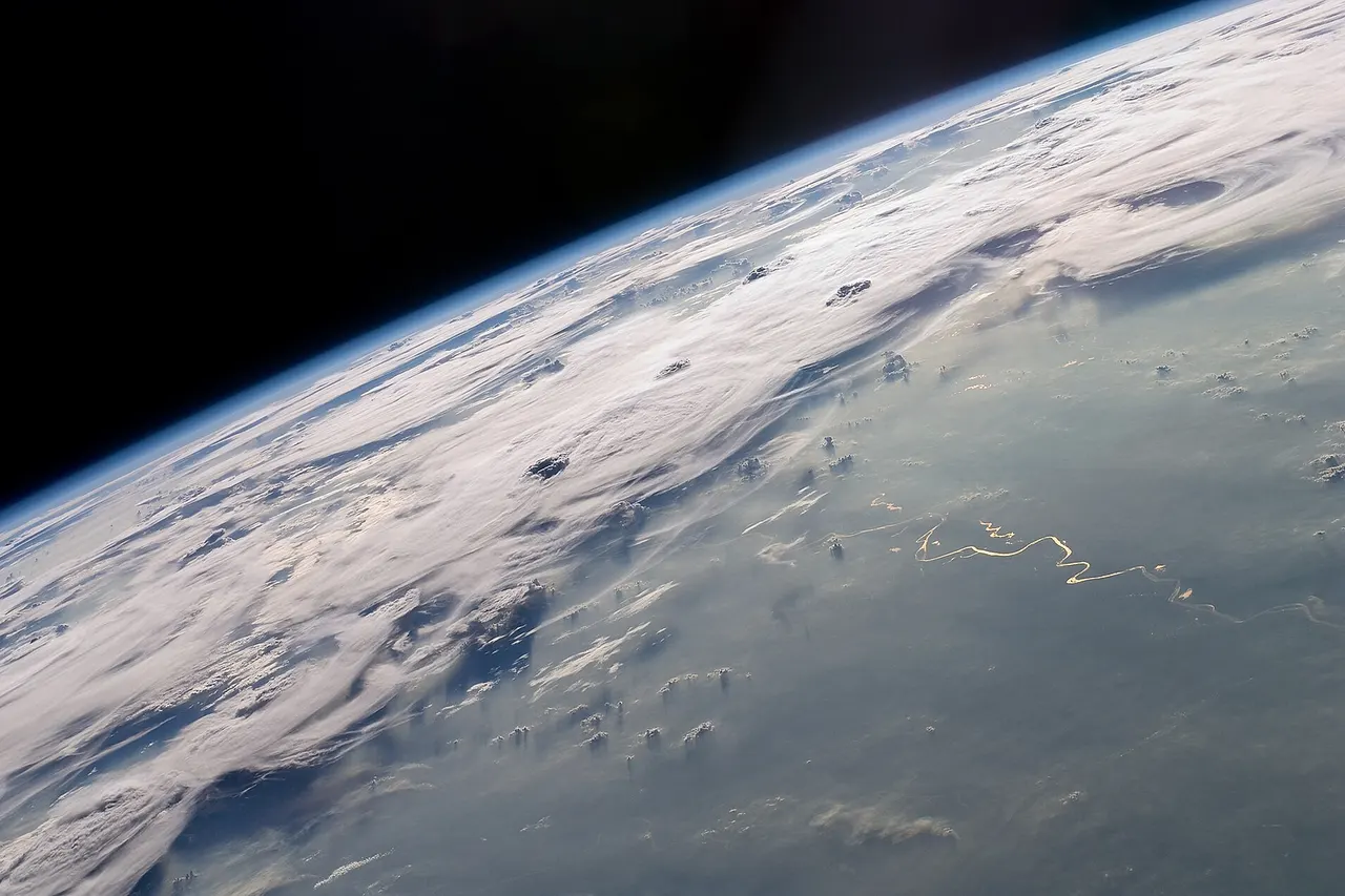 A picturesque line of thunderstorms and numerous circular cloud patterns filled the view as the International Space Station (ISS) Expedition 20 crew members looked out at the limb (blue line on the horizon) of the Earth . The region shown in the photograph includes an unstable, active atmosphere forming a large area of cumulonimbus clouds in various stages of development. The crew was looking west-south-west from the Amazon Basin , along the Rio Madeira toward Bolivia when the image was taken. The distinctive circular patterns of the clouds in the photograph are likely caused by the ageing of thunderstorms. Such ring structures often form during the final stages of storms development as their centres collapse. Sun-glint, the mirror-like reflection of sunlight off a water surface directly back to the camera on-board the ISS—is visible on the waters of the Rio Madeira and Lago Acara in the Amazon Basin. Widespread haze over the basin gives the reflected light an orange hue. The Rio Madeira flows northward and joins the Amazon River on its path to the Atlantic Ocean . A large smoke plume near the bottom centre of the image may be one source of the haze. The image was acquired with a Nikon D2Xs digital camera using an effective 48mm lens (28-70 mm zoom lens), and is provided by the ISS Crew Earth Observations experiment and Image Science & Analysis Laboratory, Johnson Space Centre.