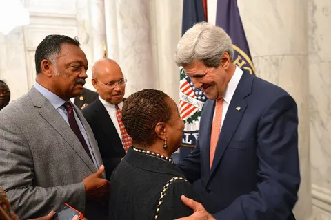 With Rev. Jesse Jackson looking on, U.S. Secretary of State John Kerry chats with Former Senator Carol Moseley Braun after the Secretary spoke at a Congressional-hosted reception for African leaders on Capitol Hill in Washington, D.C., on August 4, 2014. Leaders from across the African continent are in the nation's capital for a three-day U.S.-Africa Leaders Summit, the largest event any U.S. President has held with African heads of state and government. [State Department photo/ Public Domain]