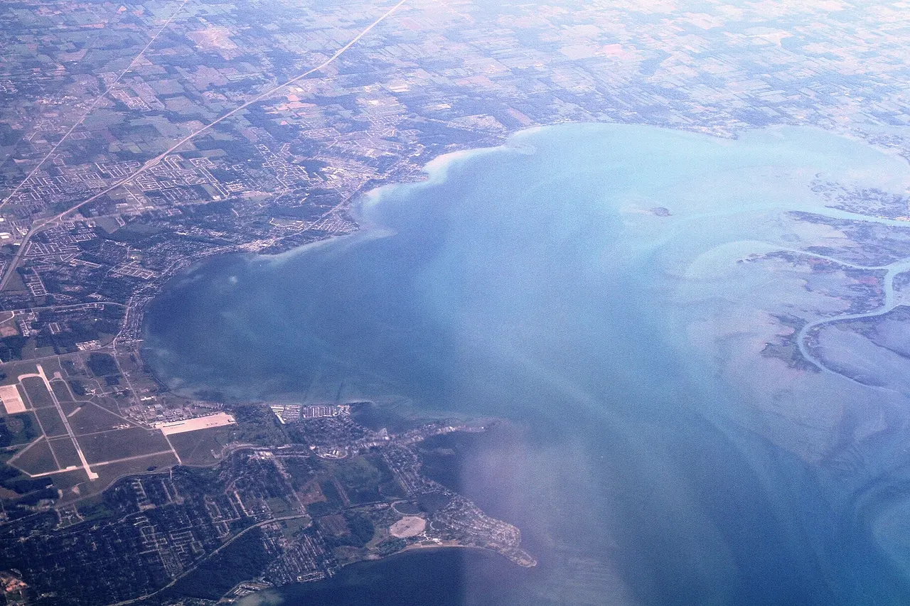 Aerial view from the south towards north, over Macomb County, southeastern Michigan. This county surrounds Detroit city in the north and northeast of the metropolitan area. The Anchor Bay is a part of Lake St Clair, by the estuary of the St Clair River which borders the United States and Canada.
