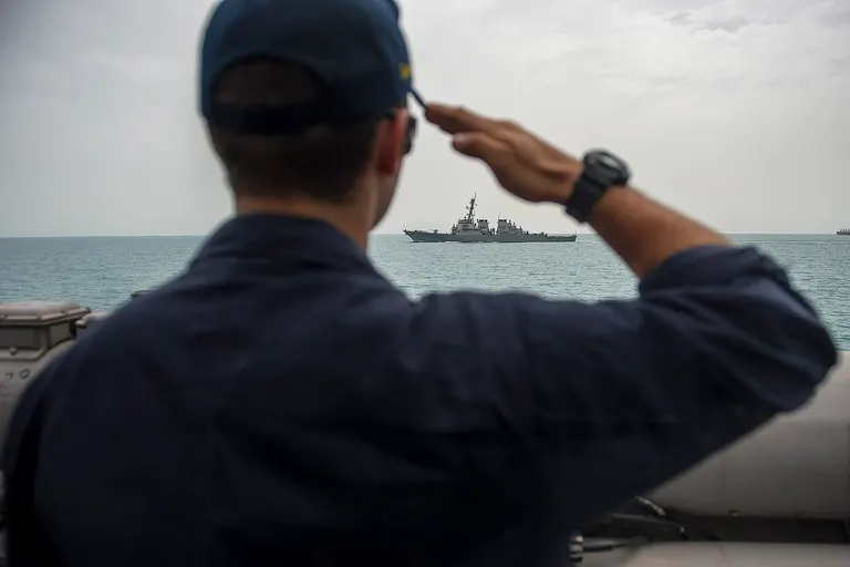 U.S. 5TH FLEET AREA OF RESPONSIBILITY (April 2, 2014) A Sailor renders honors to the USS Arleigh Burke (DDG 51) as she passes alongside Arleigh Burke-class guided-missile destroyer USS Roosevelt (DDG 80). Roosevelt is deployed as part of the George H. W. Bush Carrier Strike Group supporting maritime security operations and theater security cooperation efforts in the U.S. 5th Fleet area of responsibility. (U.S. Navy photo by Mass Communication Specialist 2nd Class Justin Wolpert/Released)