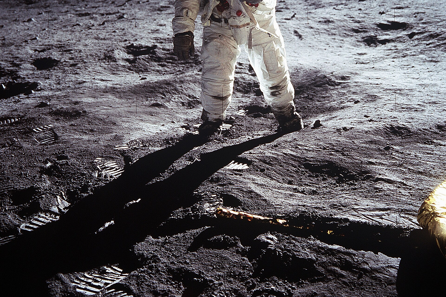 Short description : Astronaut Buzz Aldrin on the Moon Full description : Astronaut Buzz Aldrin , Lunar Module pilot, walks on the surface of the Moon near the leg of the Lunar Module (LM) "Eagle" during the Apollo 11 extravehicular activity (EVA). Astronaut Neil A. Armstrong , commander, took this photograph with a 70mm lunar surface camera. While astronauts Armstrong and Aldrin descended in the Lunar Module (LM) "Eagle" to explore the Sea of Tranquility region of the Moon, astronaut Michael Collins, command module pilot, remained with the Command and Service Modules (CSM) "Columbia" in lunar orbit. Variations : The upper black band is an addition to the original photo, carried out for "reasons of balance". See the original photo and the explanation of the edit at NASA's website . In the expanded version of the photo, it is possible to see a horizontal white line at the top left (viewer's right) of the helmet. This is the base of the antenna that was cut in the original frame of the photo.