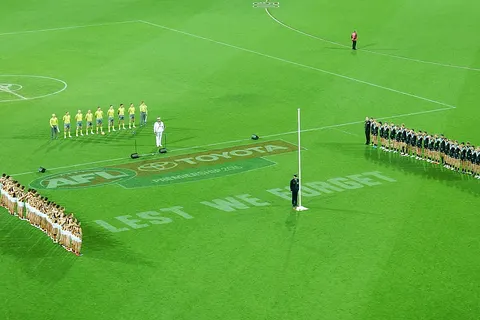 Teams and Umpires Stand to Attention
