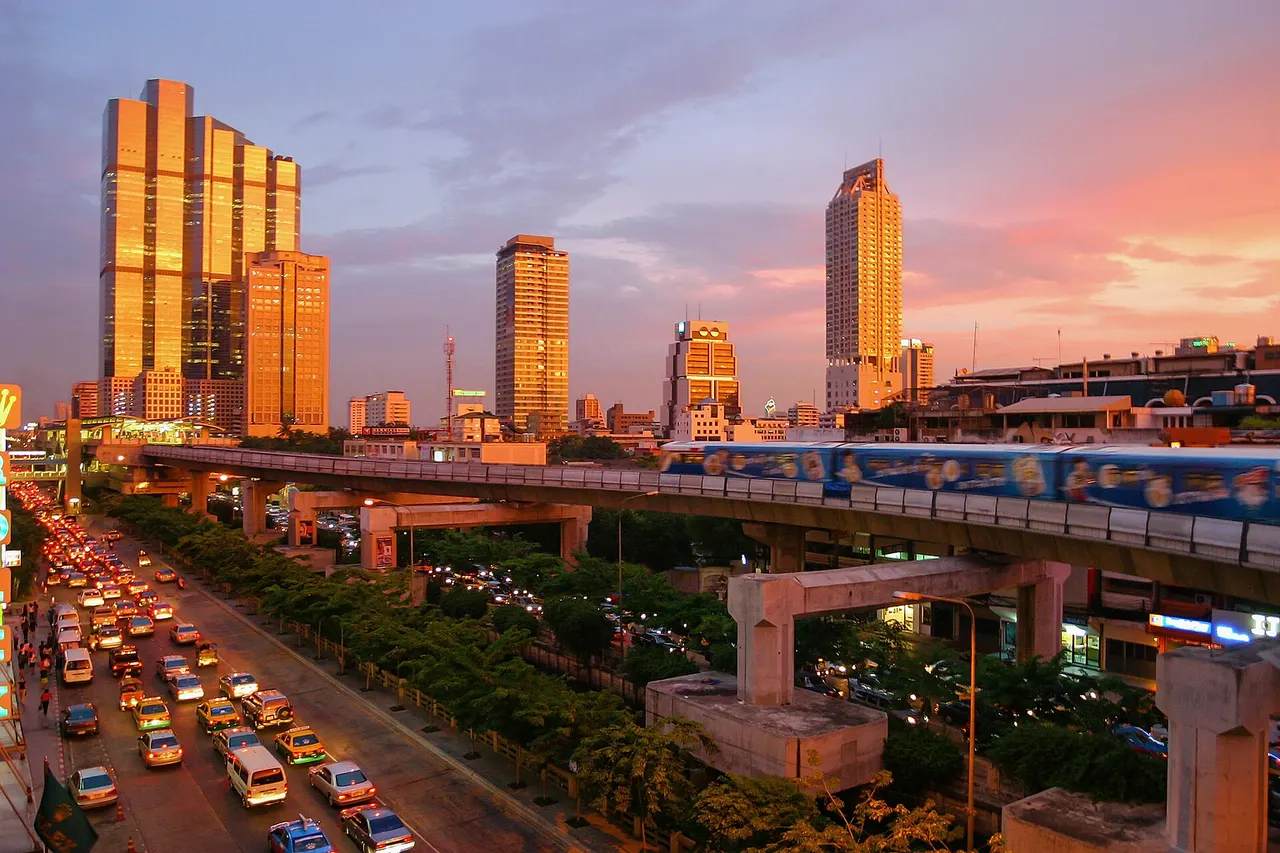 A spectacular sunset in Bangkok, showing the skytrain and modern skyline down Thanon Naradhiwas Rajanagarindra, taken from the corner of Thanon Silom, with the Empire Tower and the Chong Nonsi BTS Station at the left side.