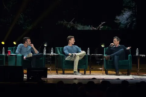 Jon Favreau, Tommy Vietor, and guest Seth Meyers at a live taping of Pod Save America at Radio City Music Hall in New York City.