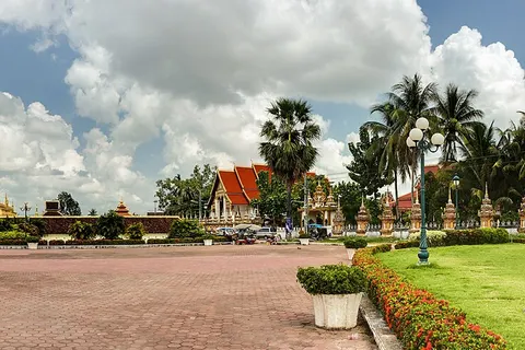 Pha That Luang stupa (center), the national symbol of Laos, and statue of king Setthathirat (left), Vientiane, Laos.