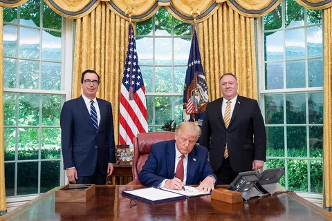 President Donald J. Trump , joined by Secretary of the Treasury Steven Mnuchin and Secretary of State Mike Pompeo , signs the unanimously approved H.R. 7440, the Hong Kong Autonomy Act and " The President’s Executive Order on Hong Kong Normalization ", Tuesday, July 14, 2020, at his desk in the Oval Office of the White House. (Official White House Photo by Tia Dufour)