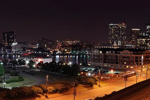 A four segment panorama of Baltimore's Inner Harbor skyline taken at night from Federal Hill .