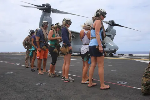 National Oceanic Atmospheric Administration (NOAA) personnel standby before being escorted onto an MV-22B Osprey en route to Midway Atoll, Hawaii as part of the MEU’s WESTPAC 14-2 deployment Aug. 8, 2014. The recovery of NOAA personnel was executed because of the threat of hurricane Iselle, the first hurricane to strike the Hawaii islands in more than two decades, which threatened the safety of the researchers. (U.S. Marine Corps photo by Cpl. Demetrius Morgan/RELEASED)