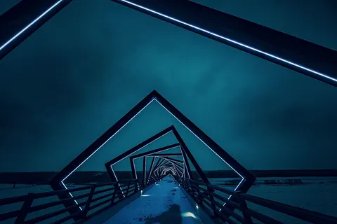 Modern geometric neon bridge architecture at night on walkway, High Trestle Trail Bridge, Madrid, Iowa, United States