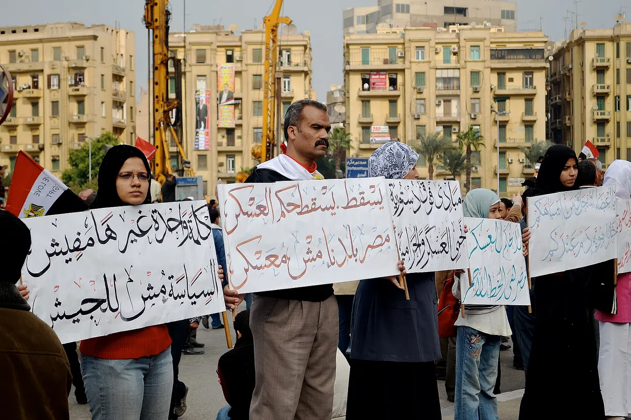 This man's sign reads "Down, down with military rule. Egypt our country is not a military camp."