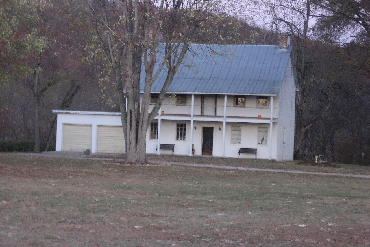 Front of the Eighteen Mile House , located at the intersection of Harrison Pike and Patriot Drive southeast of Harrison in Harrison Township , Hamilton County , Ohio , United States . Built in 1800, it has been both a house and a post office in the past, and it is listed on the National Register of Historic Places .