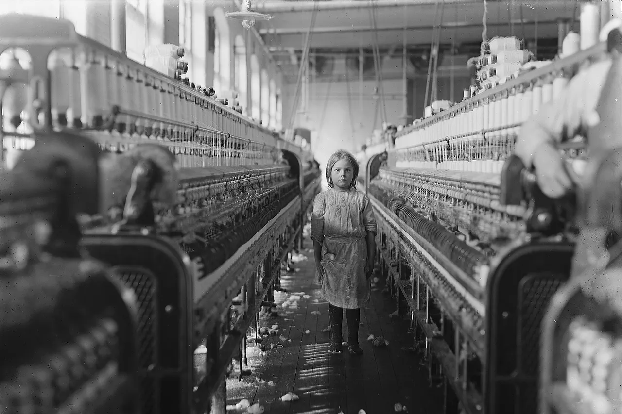 "A little spinner in the Mollohan Mills, Newberry, S.C. She was tending her 'sides' like a veteran, but after I took the photo, the overseer came up and said in an apologetic tone that was pathetic, 'She just happened in.' Then a moment later he repeated the information. The mills appear to be full of youngsters that 'just happened in,' or 'are helping sister.' Dec. 3, 08. Witness Sara R. Hine. Location: Newberry, South Carolina"